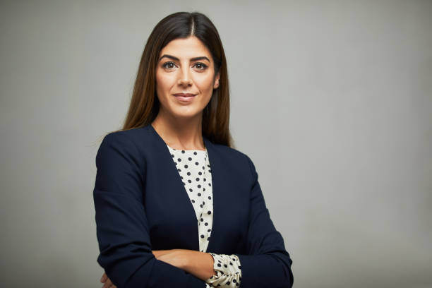 Studio waist up portrait of a beautiful businesswoman with crossed arms. Studio headshot on white background. Spanish model. brown hair photos stock pictures, royalty-free photos & images
