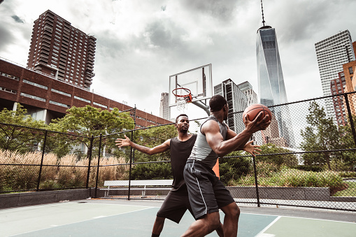 friends playing street basketball in nyc