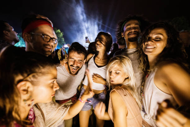 istock Large group of cheerful people having fun on a night party. 1180928729