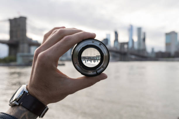 hand holding a lens against new york city skyline - down view imagens e fotografias de stock