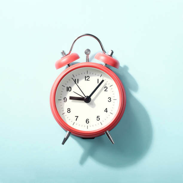istock Red alarm clock with shadow lying on blue background. View from above. 1180929374