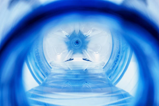 istock Close-up of a Lying Open Plastic Bottle with Leftover Water, Visible Bottom and Reflections. Global Warming, Water Supply Shortage Concept. 1180930174