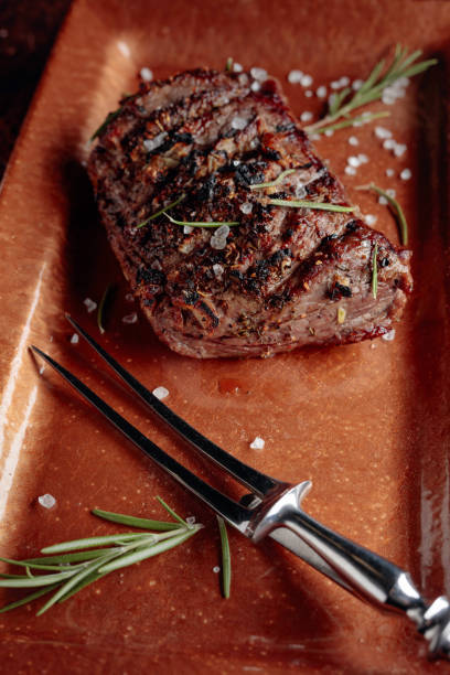 istock Grilled  beef steak with rosemary and salt on a copper plate. 1180930247