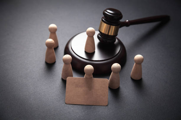 istock Human figures with gavel on black background. 1180930380