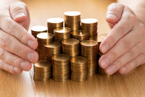 istock Man's hand with stacked coins 1180931351
