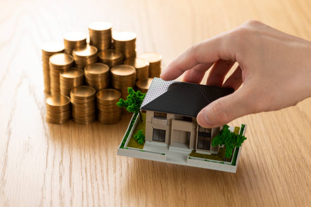 istock Man holding a house model in his hand 1180931875