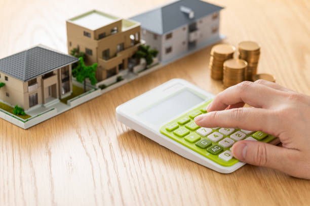 Man and house model calculating with calculator Man and house model calculating with calculator counting photos stock pictures, royalty-free photos & images