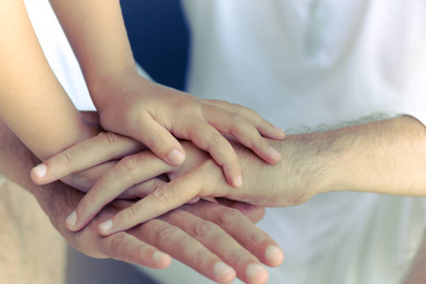istock Parent and child with hands clasped. 1180932647