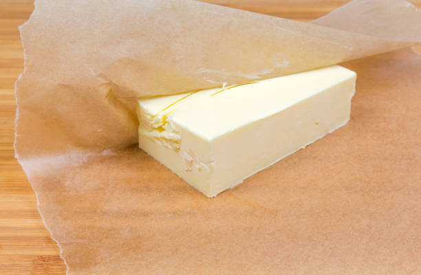 istock Piece of solid butter in waxed paper close-up 1180935899
