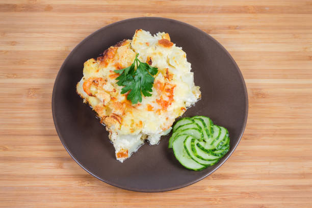 istock Cauliflower and seafood gratin portion on brown dish, top view 1180937102