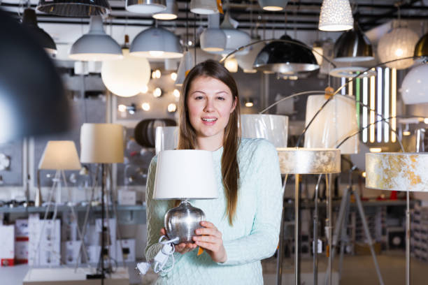 istock Smiling woman customer choosing torchere in store 1180937246