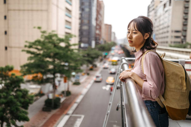 Sad female student looking at view from bridge