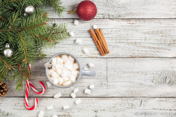 istock Winter hot drink. Christmas hot chocolate or cocoa with marshmallow on white with christmas decorations 1180942425