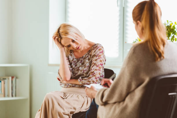 istock Depressed woman with therapist at community center 1180944521