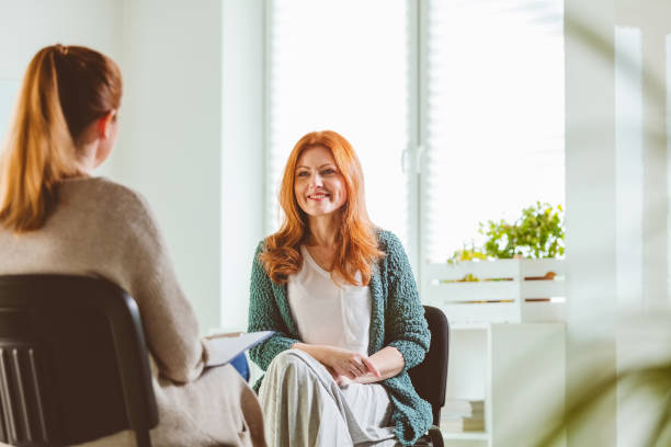 mulher de sorriso com o terapeuta no centro de comunidade - naturopath - fotografias e filmes do acervo