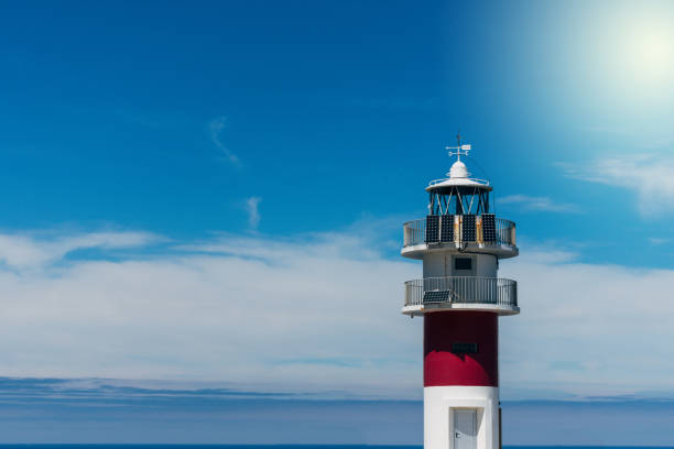 istock maritime lighthouse on cliff with blue sea in the background 1180947164