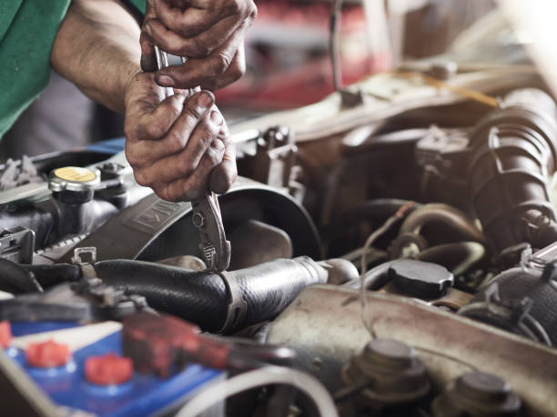 o homem do mecânico de automóvel está reparando o carro com alicates. serviço de carro, reparação, manutenção e conceito de pessoas. - mechanic auto repair shop manual worker men - fotografias e filmes do acervo