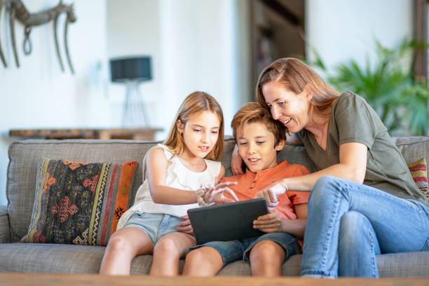 istock Mother with Young Children Using Digital Tablet at Home 1180950021