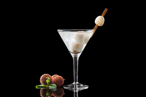 Lychee Martini on a black background. Isolate with reflection.