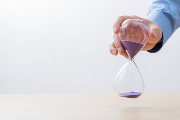 istock Man in a shirt with an hourglass in his hand 1180951704
