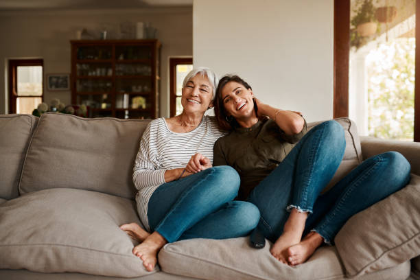 We always make it a point to hang out Full length portrait of an affectionate young woman spending time with her elderly mother in their living room at home gray hair young woman stock pictures, royalty-free photos & images