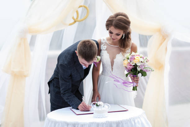 cérémonie de mariage. le marié signe le document - traditional ceremony sign symbol wedding photos et images de collection
