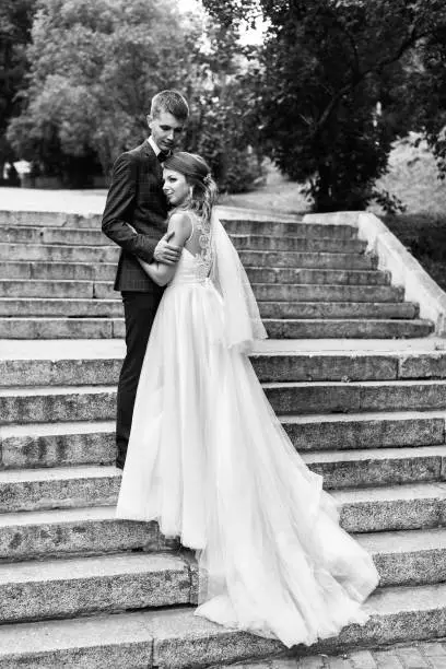 Photo of The bride and groom on the steps of the stairs. Newlyweds