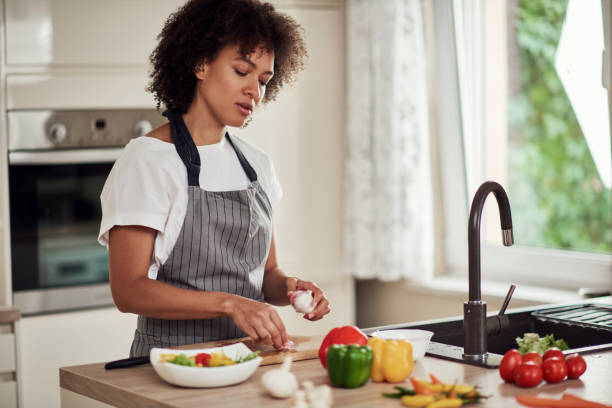 istock Woman peeling garlic. 1180953313