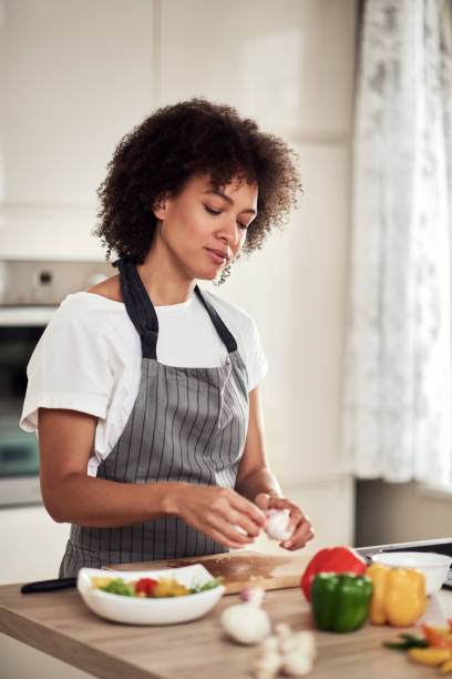 istock Woman peeling garlic. 1180953328