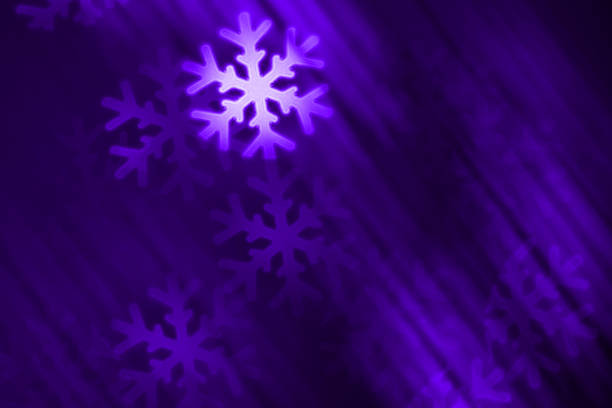 DSLR photo - defocused bokeh with snowflakes shape on a purple background (with blurred motion effect). Space for copy. Can be used as a Christmas / winter background. It's a REAL bokeh photo, not an illustration or computer filter.