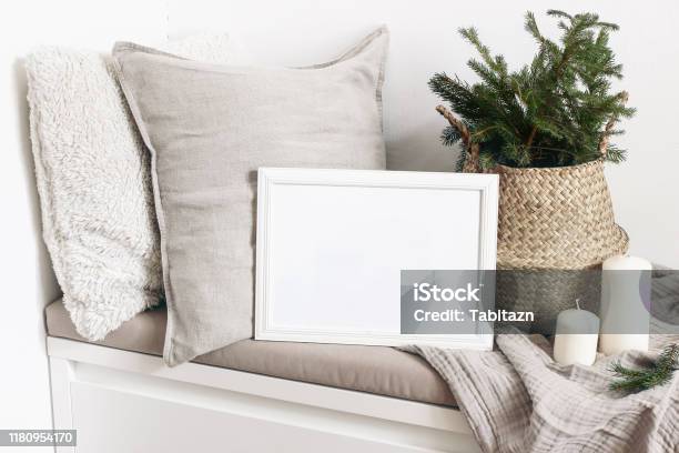 White Blank Wooden Frame Mockup With Christmas Tree Candles Linen Cushions And Plaid On The White Bench Poster Product Design Scandinavian Home Decor Nordic Design Winter Festive Concept Stock Photo - Download Image Now