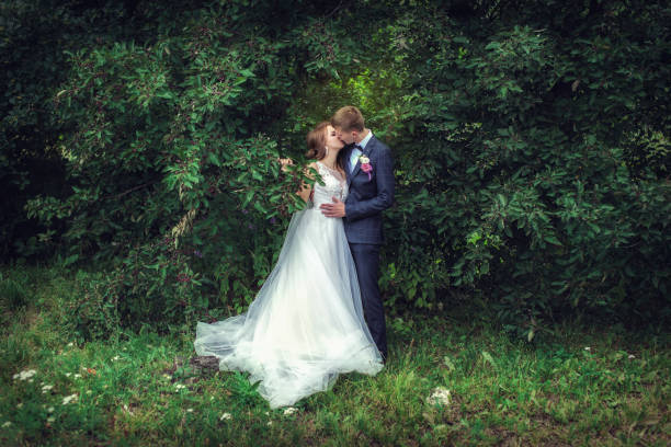 Wedding walk. Newlyweds near the green tree