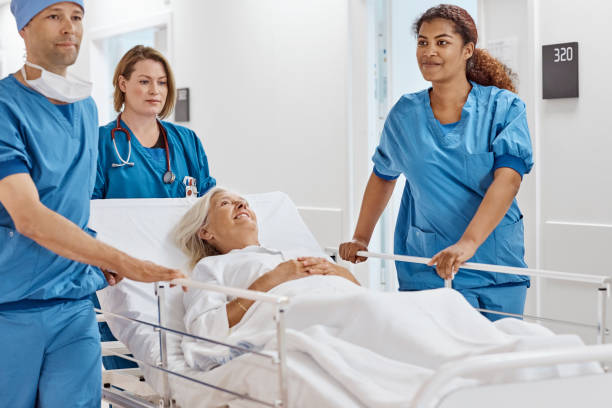 istock Surgeons pushing senior patient on hospital gurney 1180955661