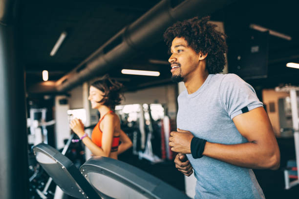 istock Teamwork in gym. Couple working exercise together. 1180955664