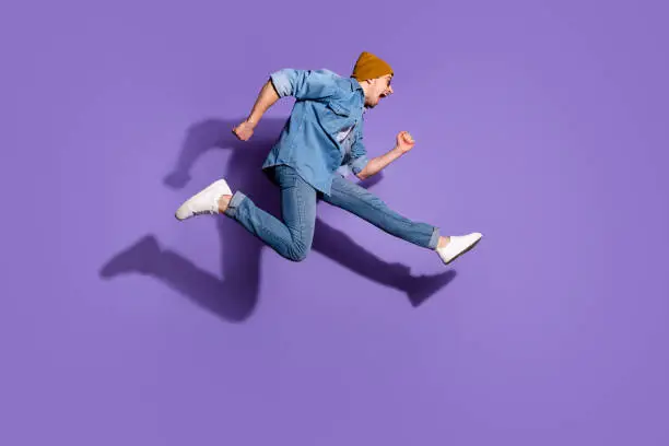 Photo of Full length body size photo of shouting urgent hurrying screaming side profile guy aspiring to buying discounted goods wearing denim jacket footwear isolated over vivid purple color background