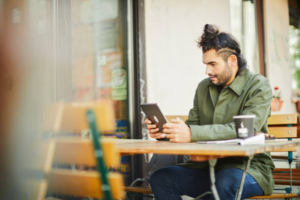 istock Lifestyle young man working with a digital tablet on a coffee shop. 1180956024