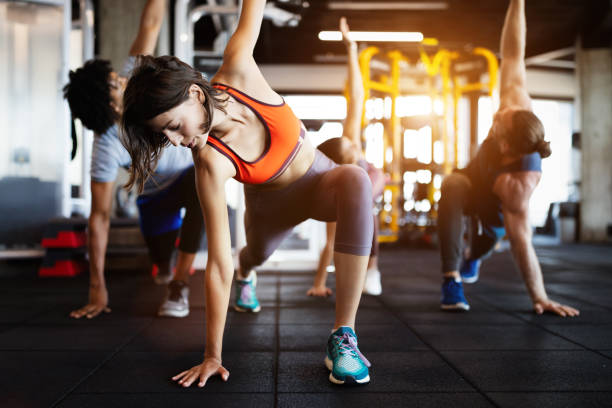 istock Group of young people doing exercises in gym 1180956463