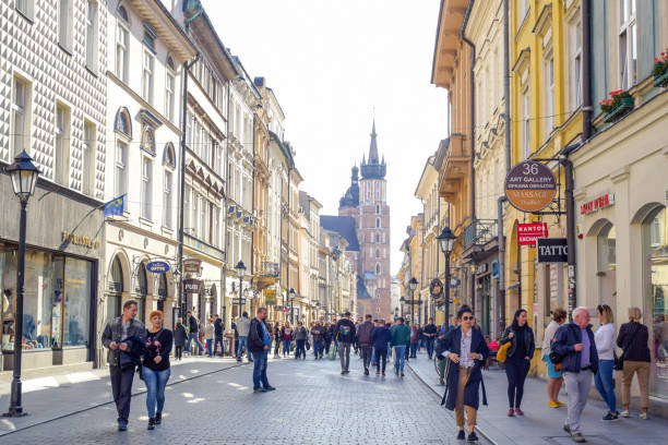 turisti in via florianska con la chiesa della basilica di santa maria sullo sfondo, la strada più famosa di cracovia, polonia - florianska street foto e immagini stock