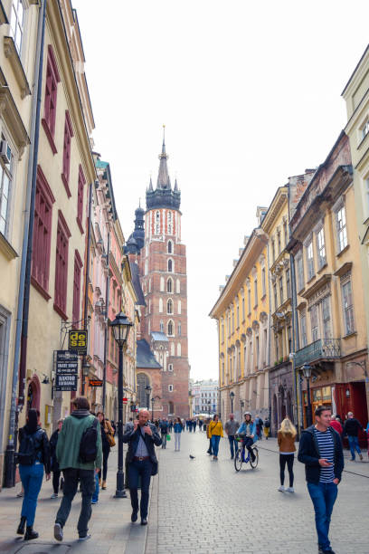 turistas en la calle florianska con la iglesia basílica de santa maría de fondo, la calle más famosa de cracovia, polonia - florianska street fotografías e imágenes de stock