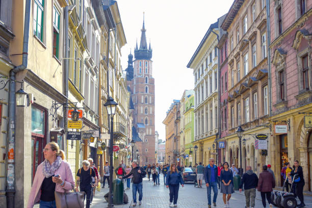 turisti in via florianska con la chiesa della basilica di santa maria sullo sfondo, la strada più famosa di cracovia, polonia - florianska street foto e immagini stock