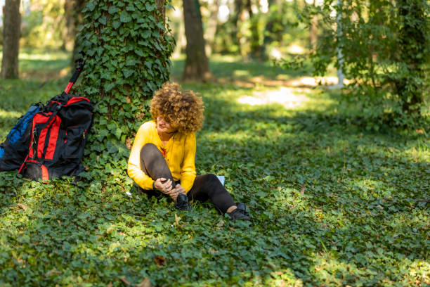 woman are injured at the ankle after hiking. hiking concept. - twisted ankle imagens e fotografias de stock