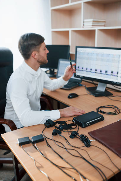 istock Vertical photo. Polygraph examiner works in the office with his lie detector's equipment 1180956853