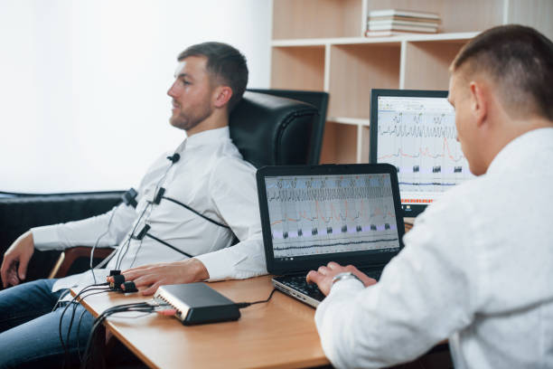 istock I wasn't be there. Suspicious man passes lie detector in the office. Asking questions. Polygraph test 1180957660