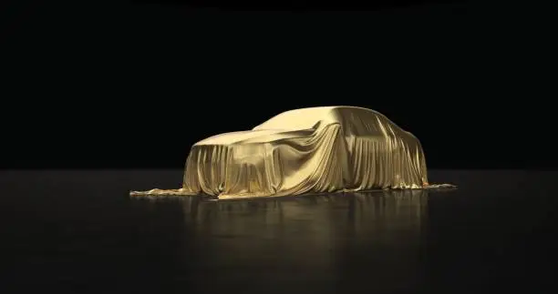 The luxury car is covered with a gold cloth on a black background.
