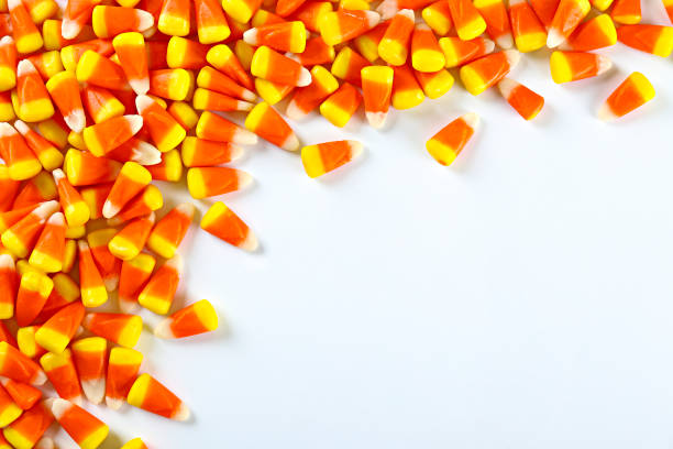 istock Bright colorful candy corn scattered on textured surface as symbol of autumnal holidays. 1180960687