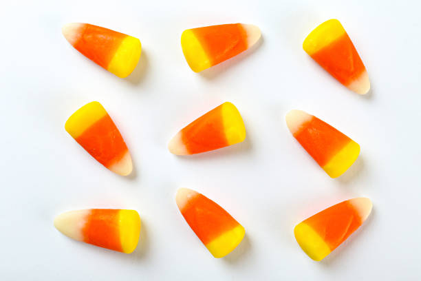 istock Bright colorful candy corn scattered on textured surface as symbol of autumnal holidays. 1180960688