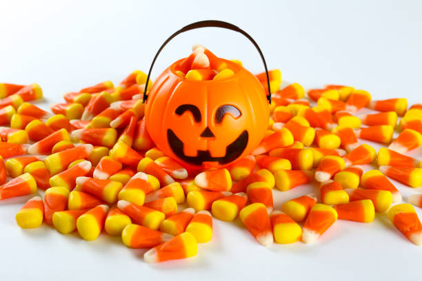 istock Bright colorful candy corn scattered on textured surface as symbol of autumnal holidays. 1180960722