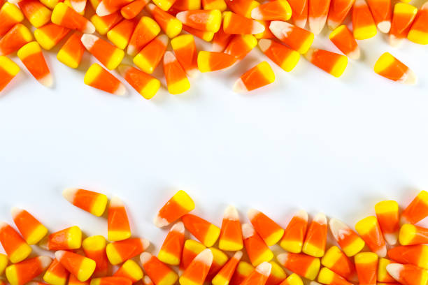 istock Bright colorful candy corn scattered on textured surface as symbol of autumnal holidays. 1180960740