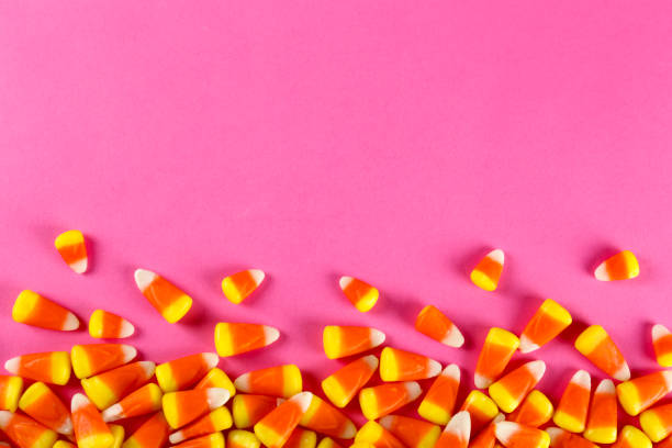 istock Bright colorful candy corn scattered on textured surface as symbol of autumnal holidays. 1180960772