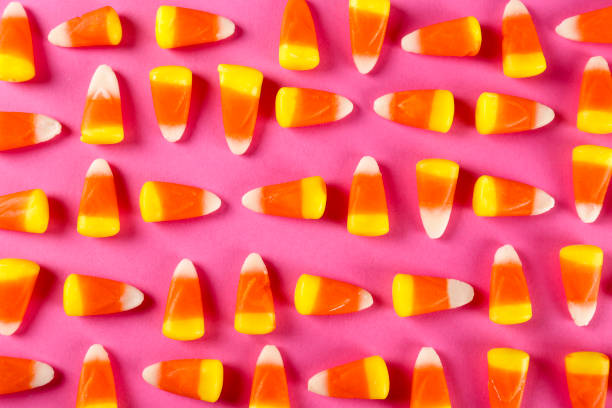 istock Bright colorful candy corn scattered on textured surface as symbol of autumnal holidays. 1180960809